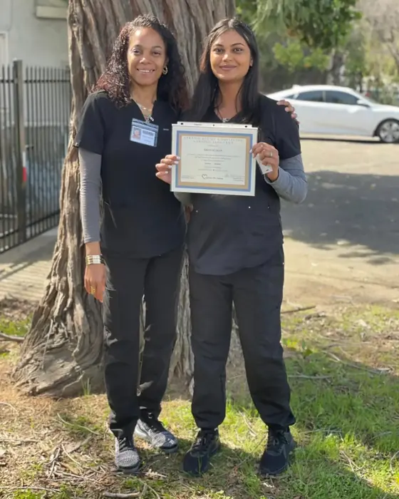 A graduate and instructor Tynesha Zacarias celebrating outdoors with her new certificate